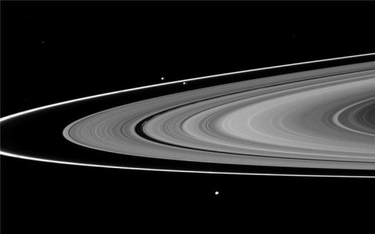 Die Hauptringe des Saturn. Der F-Ring und seine Hirtenmonde, aufgenommen von Cassini, liegt etwas außerhalb vom Rande der Hauptringe. Zwei Satelliten, zwischen denen der F-Ring liegt, sind etwas oberhalb der Bildmitte zu sehen. Es sind dies die Hirtenmonde Prometheus (innere Umlaufbahn) und Pandora (äußere Umlaufbahn.)