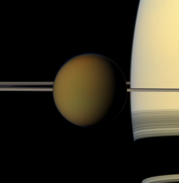Die trübe Welt des Titan ist vor Saturn und seinen Ringen in natürlichen Farben zu sehen.